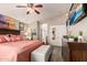 This main bedroom features a ceiling fan, natural light, and beach themed decor at 7908 W Rose Garden Ln, Peoria, AZ 85382