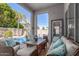 Inviting patio with wicker seating area overlooking a sparkling pool and lush backyard landscaping at 7908 W Rose Garden Ln, Peoria, AZ 85382