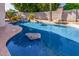 Stunning backyard pool with rock features, lush landscaping, and ample space for relaxation at 7908 W Rose Garden Ln, Peoria, AZ 85382