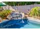 Tranquil pool waterfall with lush foliage and decorative accents at 7908 W Rose Garden Ln, Peoria, AZ 85382