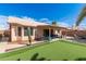 Landscaped backyard features a covered patio with seating and a putting green for outdoor fun at 8535 W Willow Ave, Peoria, AZ 85381