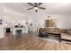 Bright living room featuring hardwood floors, white walls, ceiling fan and open access to the kitchen at 8535 W Willow Ave, Peoria, AZ 85381