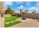 A well maintained backyard features artificial turf, desert plants, a fire pit and is enclosed by a brick wall at 1085 W Ayrshire Trl, San Tan Valley, AZ 85143