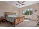 Spacious bedroom features a wooden bed frame, ceiling fan, and a large window with desert views at 1085 W Ayrshire Trl, San Tan Valley, AZ 85143