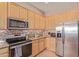 Well-lit kitchen features stainless steel appliances, granite countertops, and tiled backsplash at 1085 W Ayrshire Trl, San Tan Valley, AZ 85143