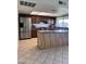 Traditional kitchen with wood cabinets, stainless steel fridge, kitchen island, and granite countertops at 11038 N 53Rd Dr, Glendale, AZ 85304