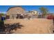 Wide view of the property backyard showcasing a metal pergola, mature trees, and a fence for added privacy at 12517 W Santa Fe Ln, El Mirage, AZ 85335