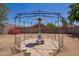 Backyard patio with metal pergola featuring an outdoor heater and space for entertaining on a paved tile surface at 12517 W Santa Fe Ln, El Mirage, AZ 85335