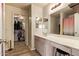Bright bathroom featuring a vanity with makeup station and walk in closet at 12517 W Santa Fe Ln, El Mirage, AZ 85335