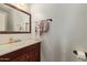 Practical bathroom featuring a vanity with a mirror, towels, and dark wood cabinets at 12517 W Santa Fe Ln, El Mirage, AZ 85335