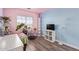 Unique bedroom with pink and blue walls, wood floors, and a modern shelving unit at 12517 W Santa Fe Ln, El Mirage, AZ 85335