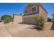 Exterior of home with a two car garage, low maintenance landscaping, and a well-maintained driveway at 12517 W Santa Fe Ln, El Mirage, AZ 85335