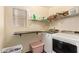 Laundry room with modern washer and dryer, folding table and window at 12517 W Santa Fe Ln, El Mirage, AZ 85335