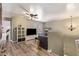 Inviting living room features wood floors, a ceiling fan, and a modern entertainment center at 12517 W Santa Fe Ln, El Mirage, AZ 85335