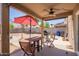 Covered patio with a red umbrella and dining table, great for entertaining guests at 12517 W Santa Fe Ln, El Mirage, AZ 85335