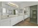 Spacious bathroom features a dual sink vanity, tiled floors, and mirrored closet doors at 14754 W Amelia Ave, Goodyear, AZ 85395