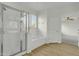 Bright bathroom featuring a glass shower, soaking tub, and wood-look floors at 14754 W Amelia Ave, Goodyear, AZ 85395