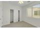 Bright bedroom featuring neutral walls, plush carpet, a ceiling fan and closet with sliding doors at 14754 W Amelia Ave, Goodyear, AZ 85395