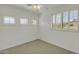 Neutral bedroom featuring three shuttered windows, plush carpeting, and a modern ceiling fan at 14754 W Amelia Ave, Goodyear, AZ 85395