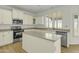 Bright eat-in kitchen with stainless steel appliances, island, and plantation shutters at 14754 W Amelia Ave, Goodyear, AZ 85395