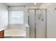 Bright bathroom with a soaking tub and glass-enclosed shower; light filled from a window with privacy blinds at 1517 E Elaine Dr, Casa Grande, AZ 85122
