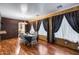A cozy dining room features wood floors, exposed brick, and contemporary table at 1517 E Elaine Dr, Casa Grande, AZ 85122