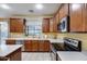 Charming kitchen boasts stainless steel appliances, a window over the sink, and wood cabinetry at 1517 E Elaine Dr, Casa Grande, AZ 85122