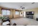 Bright living room with a ceiling fan, TV, large windows, and comfortable seating at 1517 E Elaine Dr, Casa Grande, AZ 85122