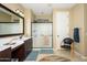 Modern bathroom featuring a vanity with dual sinks, a shower behind a frosted glass door, and tile flooring at 15796 W Shaw Butte Dr, Surprise, AZ 85379