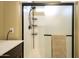 Modern bathroom shower with glass doors, sleek fixtures, and convenient shelving for a clean and functional space at 15796 W Shaw Butte Dr, Surprise, AZ 85379