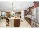 Open-concept kitchen with granite countertops, stainless steel appliances, and bar seating at 15796 W Shaw Butte Dr, Surprise, AZ 85379