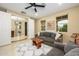 Comfortable living room with neutral walls, gray couch, ceiling fan, and plenty of natural light at 15796 W Shaw Butte Dr, Surprise, AZ 85379