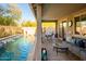 Covered patio with a seating area overlooking a pool, with ample space for entertaining and relaxing in the backyard at 15796 W Shaw Butte Dr, Surprise, AZ 85379