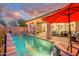 Inviting backyard pool with covered patio, lounge area, and lush landscaping, perfect for outdoor entertaining and relaxation at 15796 W Shaw Butte Dr, Surprise, AZ 85379