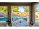 Outdoor dining area showcases a pool with water features, adorned with garden decor and shaded by mature trees at 15796 W Shaw Butte Dr, Surprise, AZ 85379