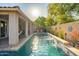 Sun-drenched pool area features a shimmering pool, lush landscaping, and a covered patio for outdoor entertaining at 15796 W Shaw Butte Dr, Surprise, AZ 85379