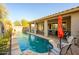 Inviting backyard pool area with a covered patio, lounge seating, and a well-maintained pool at 15796 W Shaw Butte Dr, Surprise, AZ 85379