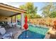 Inviting backyard oasis with a sparkling pool, charming water features, a covered patio, and manicured landscaping at 15796 W Shaw Butte Dr, Surprise, AZ 85379