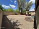 Spacious backyard with gravel, patio, block wall, and mature landscaping under a blue sky at 16010 N 170Th Ln, Surprise, AZ 85388