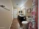 Well-lit bathroom with a double sink vanity, wood look tile floor, and framed art at 16010 N 170Th Ln, Surprise, AZ 85388