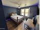 This bedroom features wood floors, a ceiling fan, and a spacious desk area at 16010 N 170Th Ln, Surprise, AZ 85388