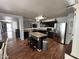 Spacious kitchen with black cabinets, a center island, stainless appliances, and wood flooring at 16010 N 170Th Ln, Surprise, AZ 85388
