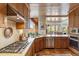 Rustic kitchen featuring wooden cabinetry, stainless steel appliances, and a breakfast bar overlooking the dining area at 1607 N Quartz Valley Rd, Scottsdale, AZ 85266