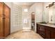 Bright bathroom featuring a glass block shower, tiled floors, wood cabinets, and granite countertop at 16211 S 4Th St, Phoenix, AZ 85048