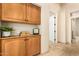 Kitchen area featuring tiled floors, wooden cabinets, and doorway to hallway at 16211 S 4Th St, Phoenix, AZ 85048
