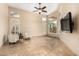 Bright living room featuring tile floors, plantation shutters, and a ceiling fan at 16211 S 4Th St, Phoenix, AZ 85048