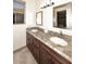 Bathroom featuring double sinks with granite countertop, mirrors, and dark wood cabinetry at 16304 E Crystal Ridge Dr, Fountain Hills, AZ 85268