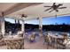 This serene covered patio has seating, ceiling fans, and mesmerizing views of the pool and landscape at 16304 E Crystal Ridge Dr, Fountain Hills, AZ 85268