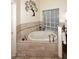 Bathroom soaking tub with tile surround and a decorative window at 16304 E Crystal Ridge Dr, Fountain Hills, AZ 85268