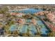 Aerial view of tennis courts and a lake surrounded by lush landscaping and community buildings at 1633 E Lakeside Dr # 139, Gilbert, AZ 85234